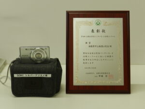 銀賞受賞の盾と副賞のディジタルカメラ